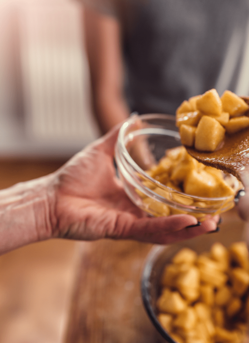 Obststücke werden in eine Schüssel gegeben