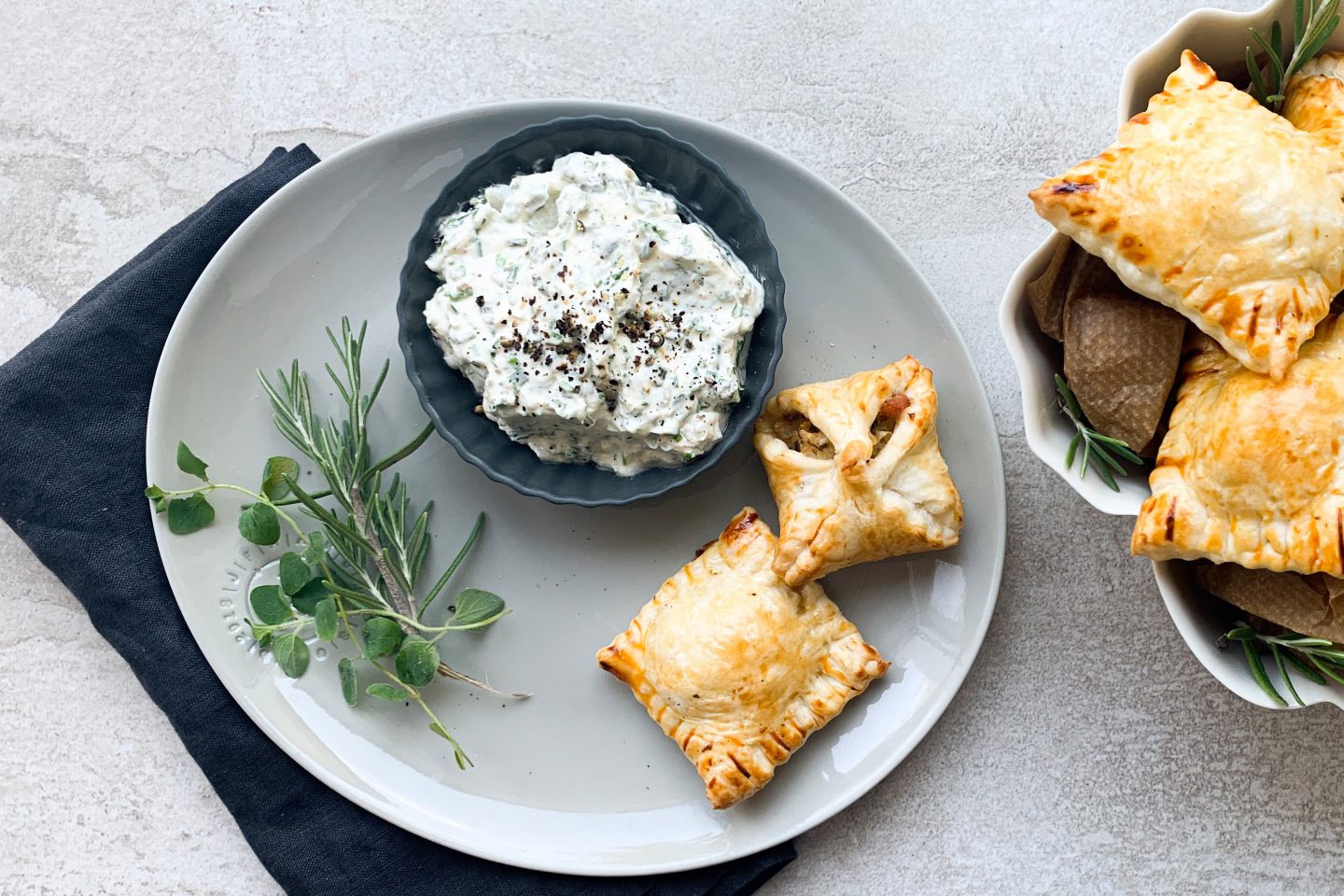 filled cabbage pastry Gefüllte Speck-Kraut-Taschen auf einem Teller mit Dip und frischen Kräutern