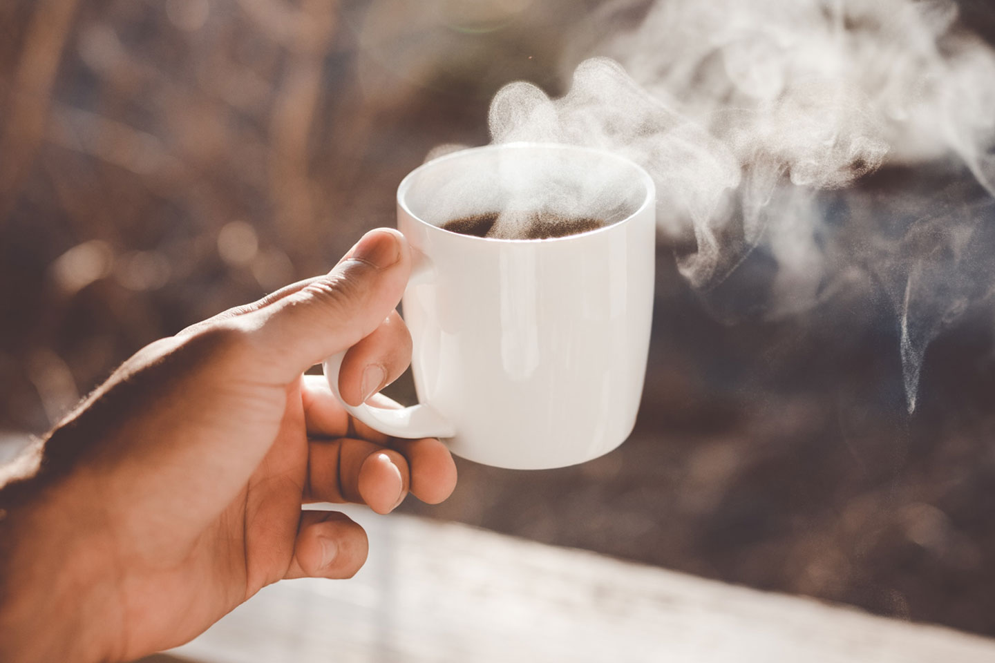 a hand is holding a cup of coffee