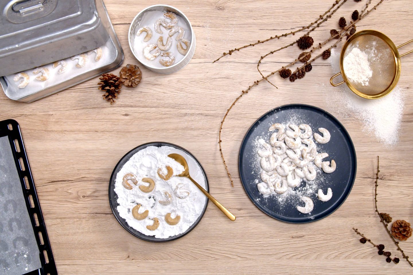 Freshly baked vanilla crescents are rolled in a vanilla sugar mixture and placed on a black plate