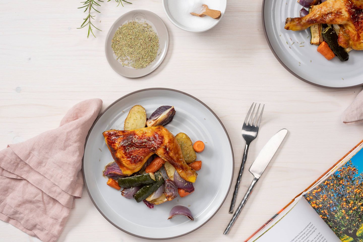 Rosemary chicken with roasted vegetables next to the current rosemary packaging.